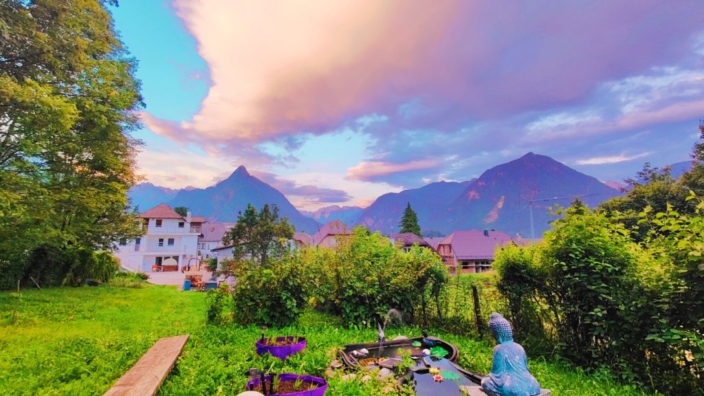 Peaceful garden view at SoÄa Home Bovec with mountains and sunset sky